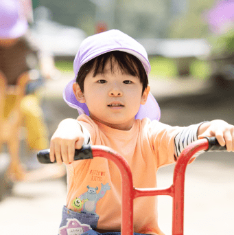 三輪車で遊ぶ園児