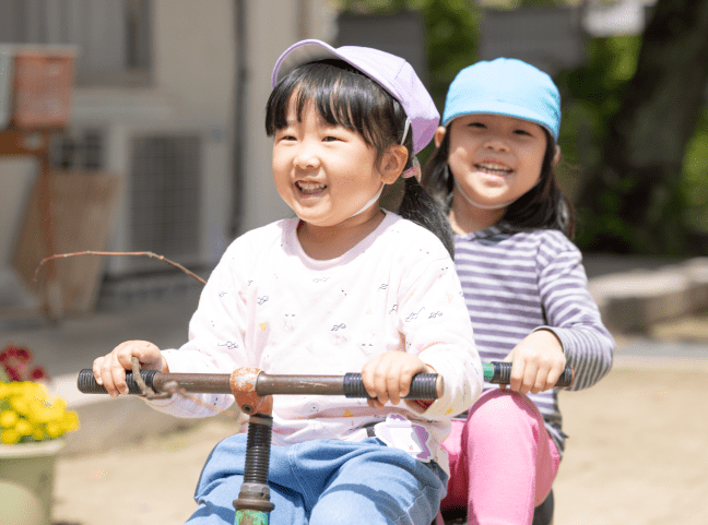 三輪車で遊んでいる女の子の園児